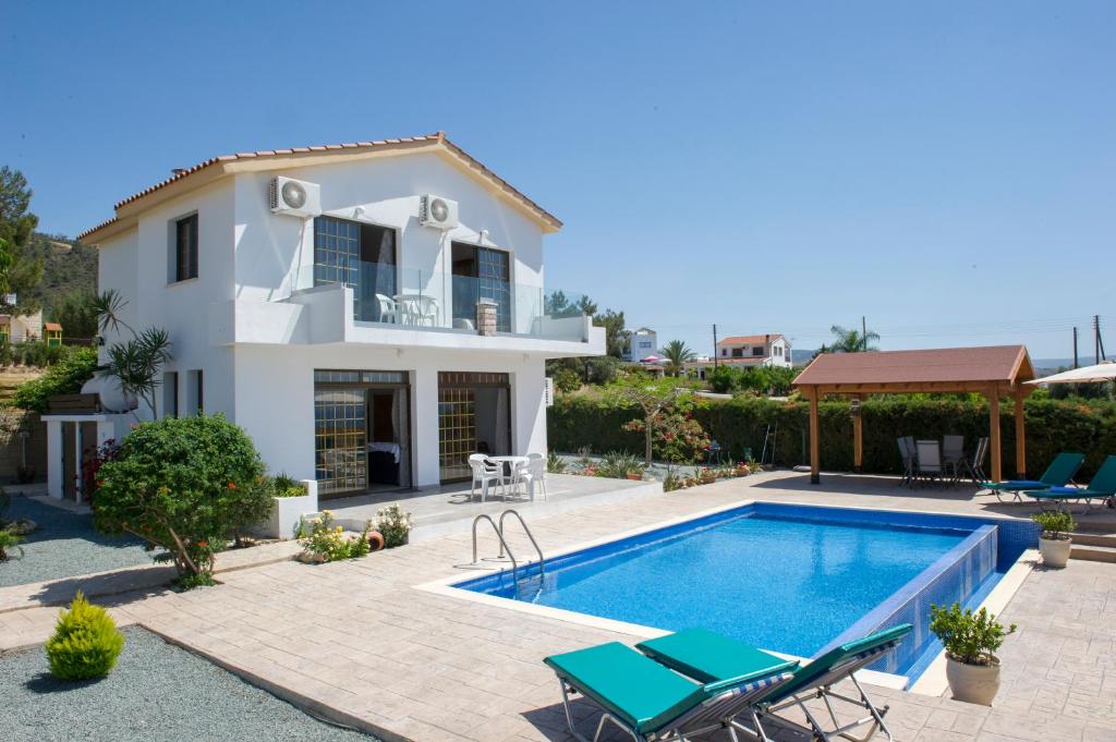 a villa with a swimming pool and a house at Savvas Villa in Argaka