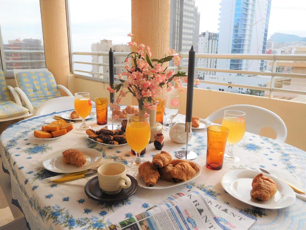 Sunny Beach Apartment في كاليبي: طاولة عليها طعام للإفطار وعصير البرتقال