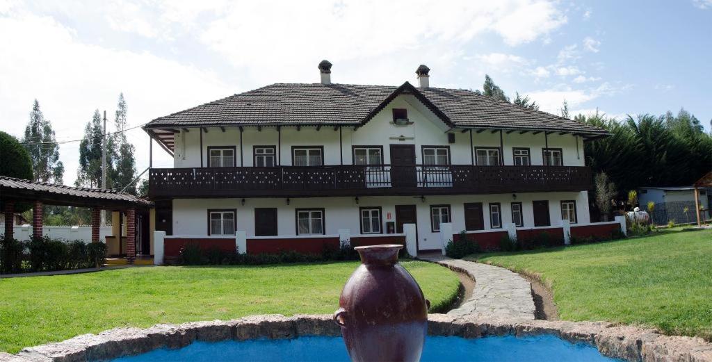 una casa grande con un jarrón delante en Centro Vacacional Huaychulo, en Concepción