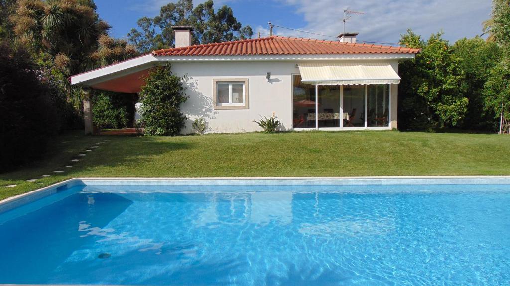 a house and a swimming pool in front of a house at Casa Landim in Landim