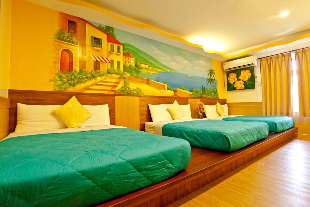 two beds in a room with a painting on the wall at Bashi Channel Vacation B&B in Kenting