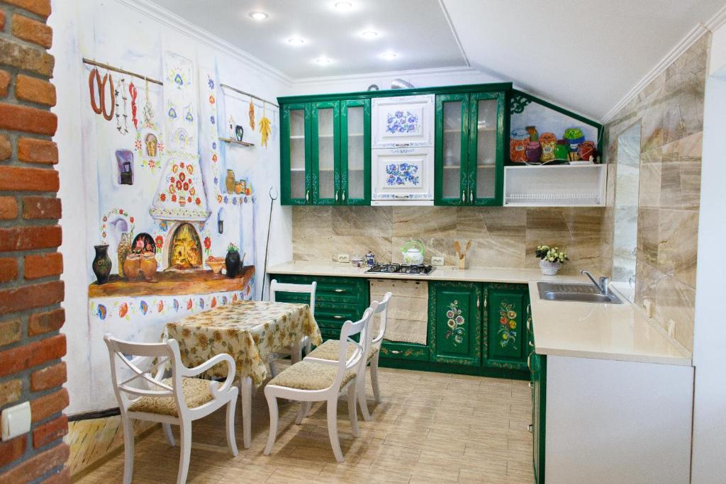 カームヤネツィ・ポジーリシクィイにあるApartments in Old Cityのキッチン(緑のキャビネット、テーブル、椅子付)