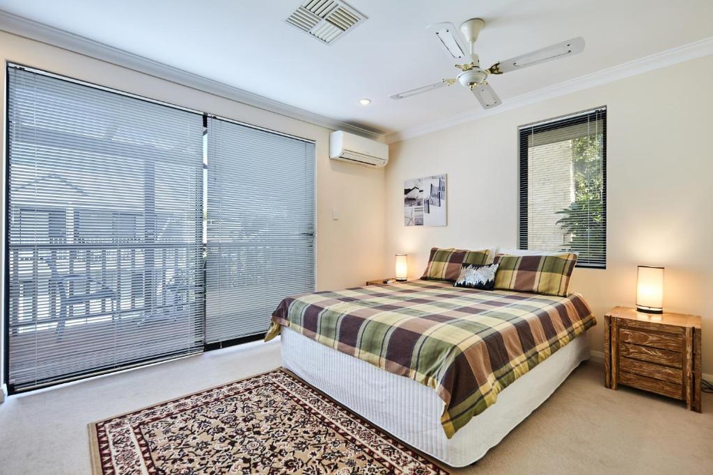 a bedroom with a bed and a large window at Fremantle Townhouse Unit 4 in Fremantle