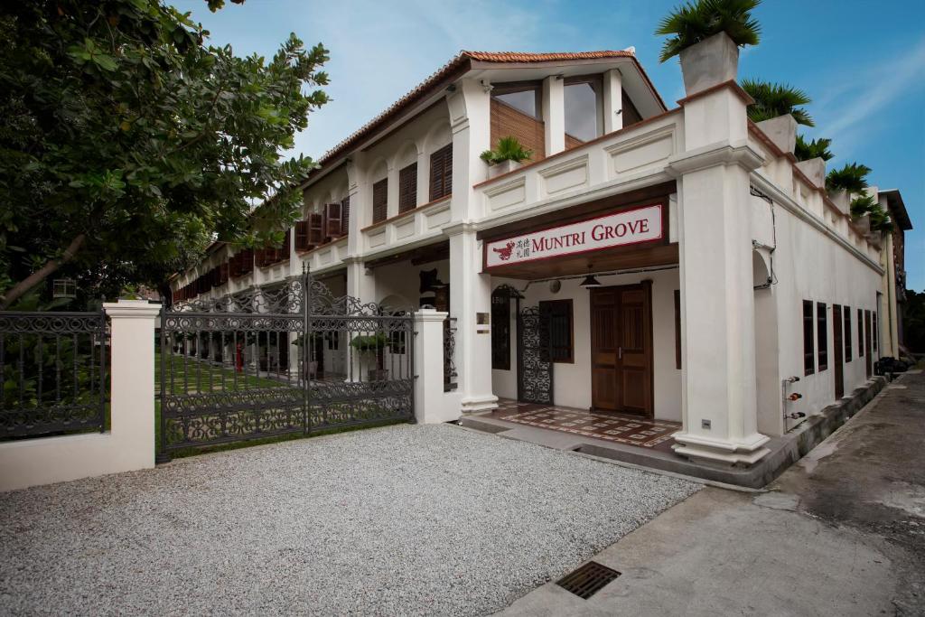 a white building with a sign that reads embassy grove at Muntri Grove in George Town