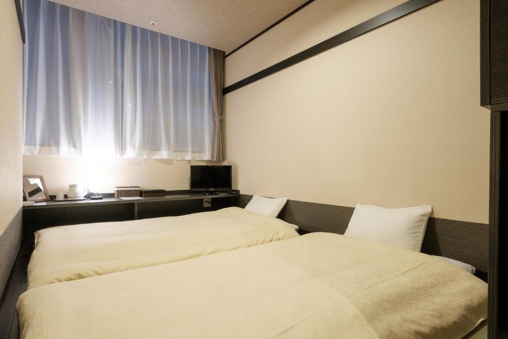 Postel nebo postele na pokoji v ubytování The Premium Hotel In Rinku