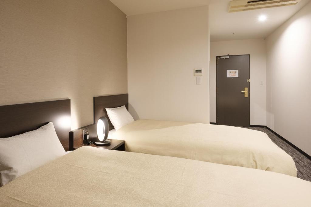 Postel nebo postele na pokoji v ubytování The Premium Hotel In Rinku