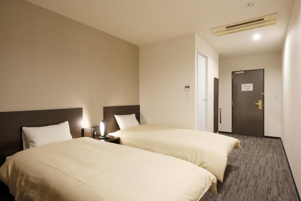 Postel nebo postele na pokoji v ubytování The Premium Hotel In Rinku