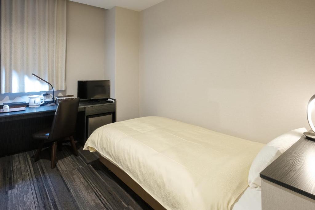 Postel nebo postele na pokoji v ubytování The Premium Hotel In Rinku