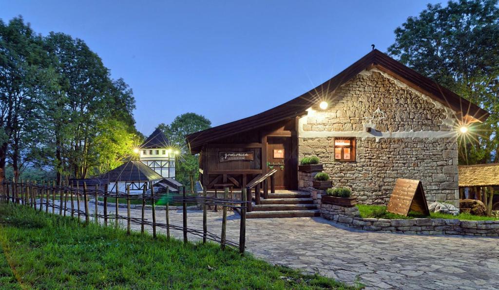 uma casa de pedra com uma cerca em frente em Farm Stay Čardaklije em Kulen Vakuf