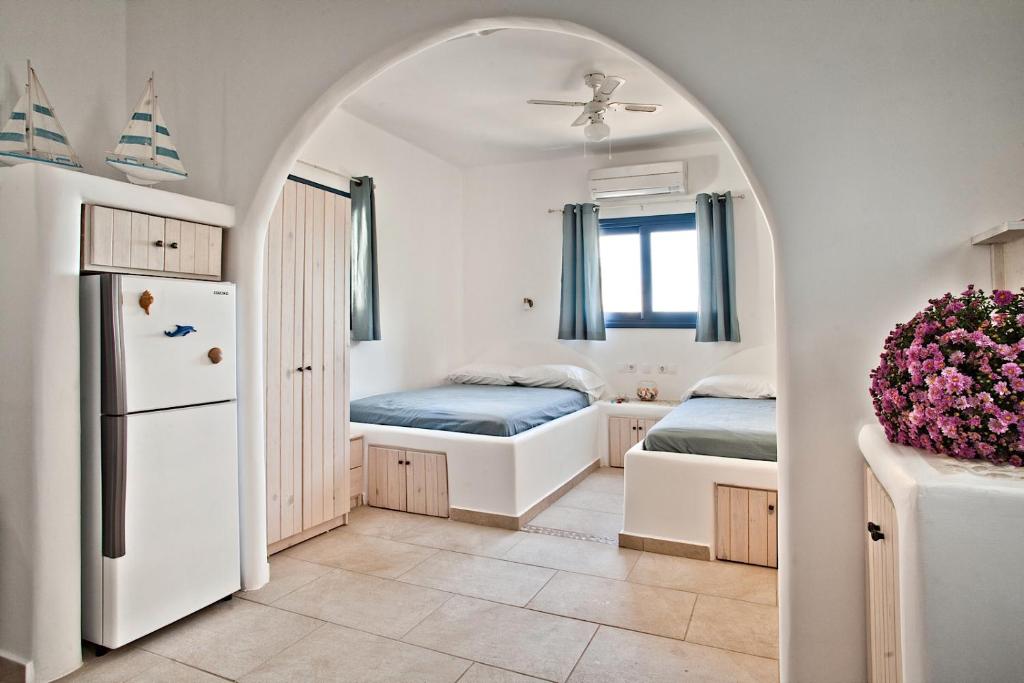 an archway in a room with two beds and a refrigerator at Villa Stamatina in Kyra Panagia