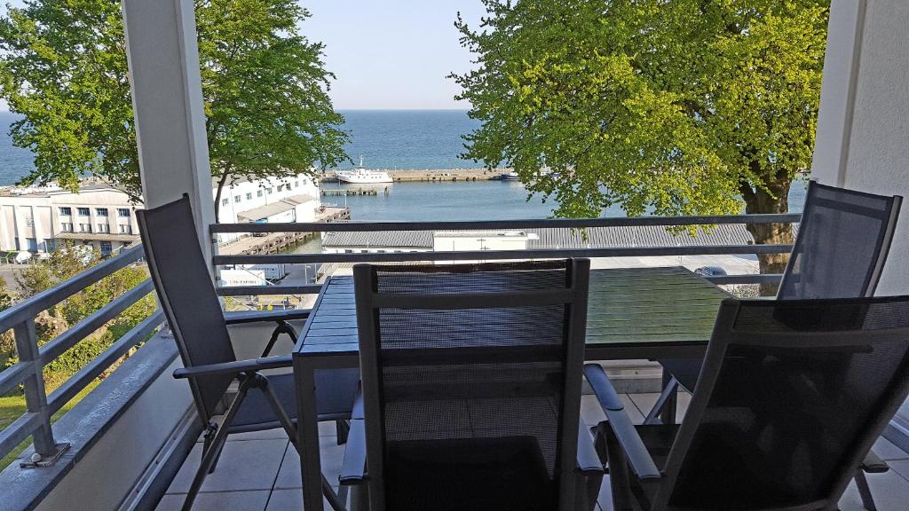 balcone con tavolo, sedie e vista sull'oceano di Ferienwohnung Hafenblick a Sassnitz
