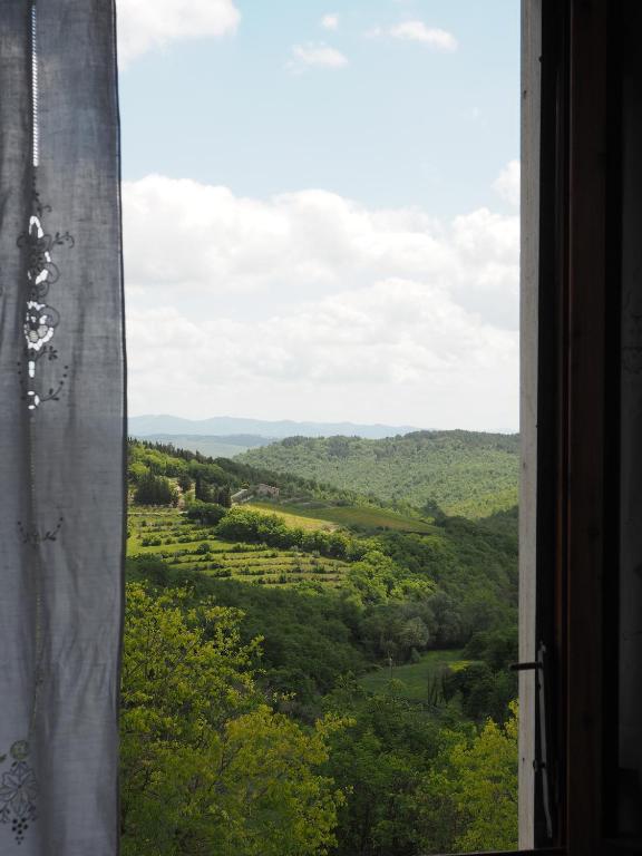 a view of a valley from a window at Casa DUILIA in Castellina in Chianti