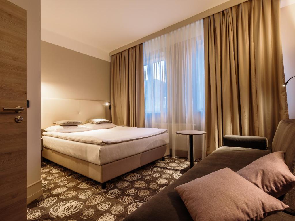 a hotel room with a bed and a window at Hotel Center Novo Mesto in Novo Mesto