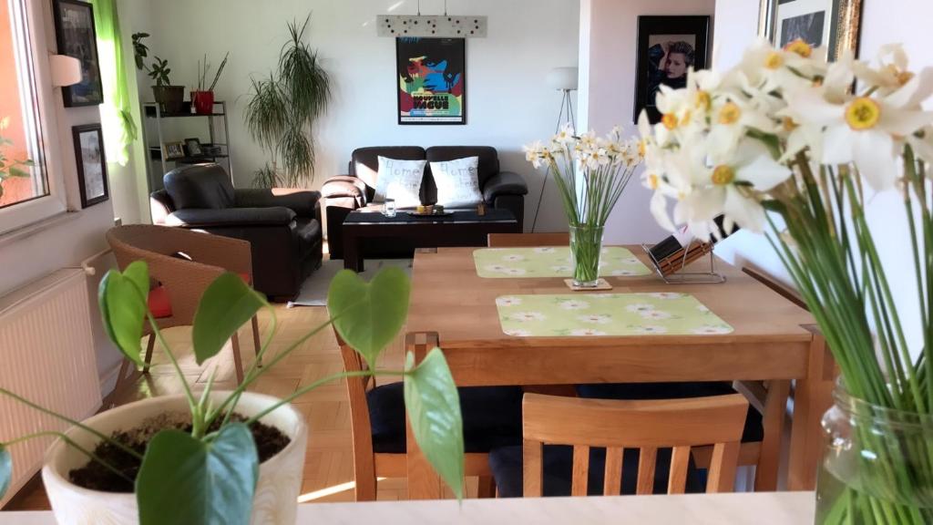 a living room with a dining room table with flowers at Orion Apartment 1 in Prishtinë