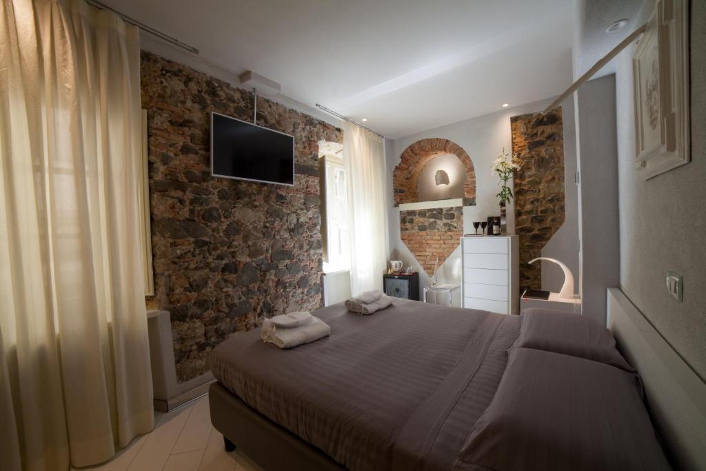 a bedroom with a bed with two towels on it at Art Boutique Hotel Acchiappasogni in Barga