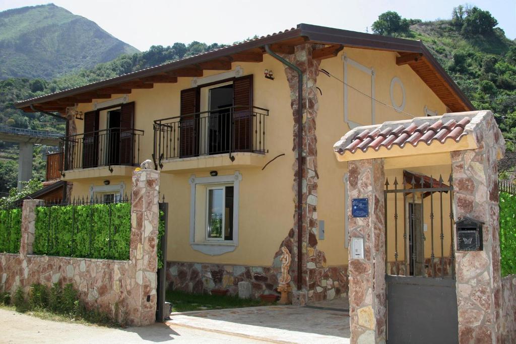 a yellow house with a porch and a balcony at Villa Paladino - B&B e Guest House in Scilla