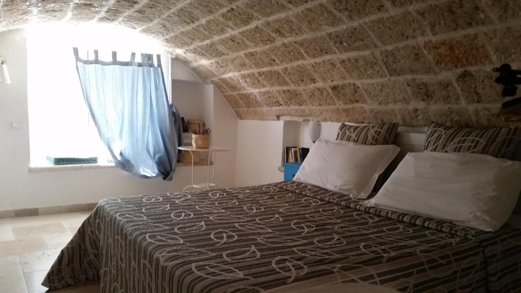 ein Schlafzimmer mit einem Bett mit einer Steinmauer in der Unterkunft Pescatore in Monopoli