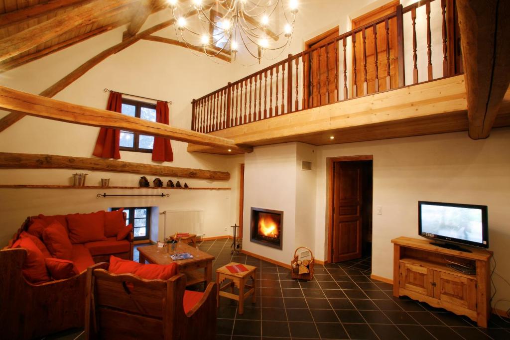 ein Wohnzimmer mit einem Sofa und einem TV in der Unterkunft Chez le Marquis du Pontet in Valloire