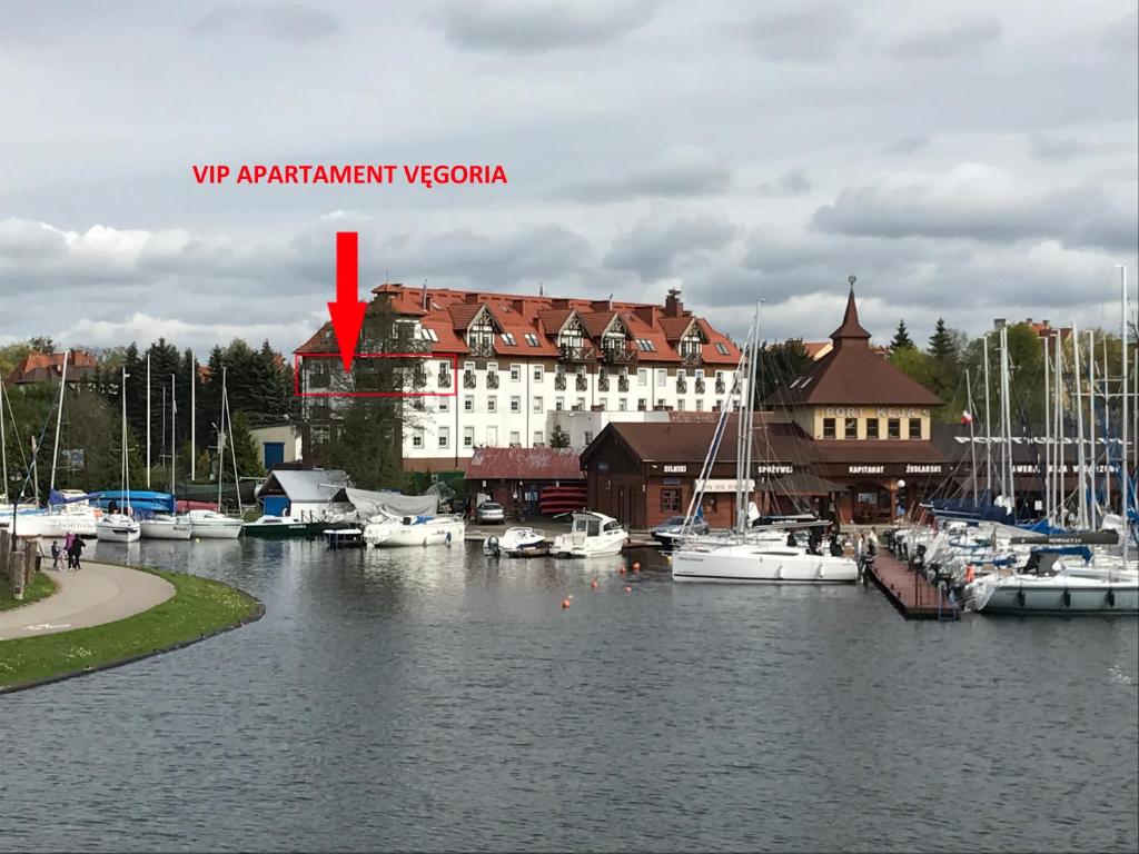 a marina with boats in the water and a building at Apartament VIP Vęgoria in Węgorzewo