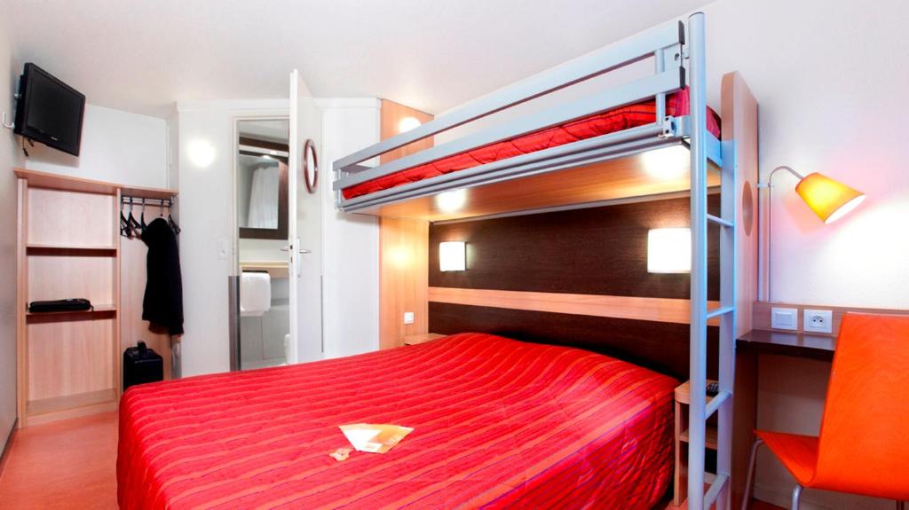 - une chambre avec des lits superposés et un couvre-lit rouge dans l'établissement Premiere Classe Dunkerque Est Armbouts Cappel, à Armbouts-Cappel