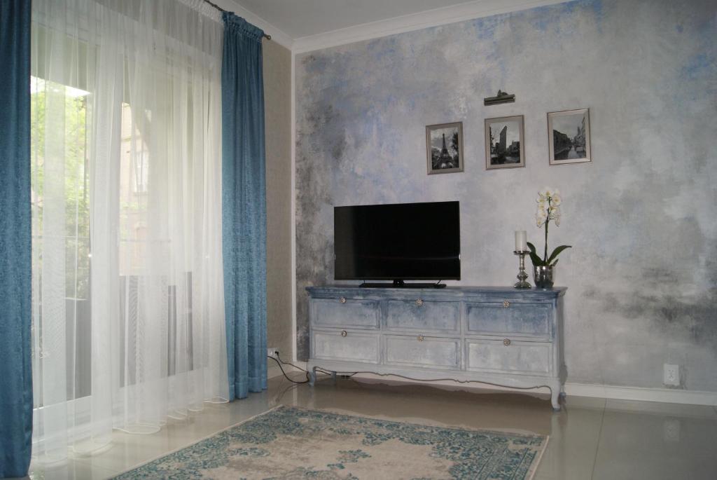 ein Wohnzimmer mit einem TV auf der Kommode in der Unterkunft Apartament pod zamkiem in Olsztyn