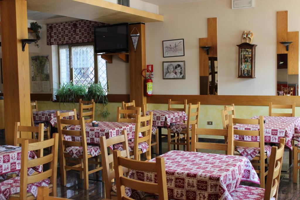 une salle à manger avec des tables et des chaises dans un restaurant dans l'établissement Albergo Napoleone, à SantʼAmbrogio di Valpolicella