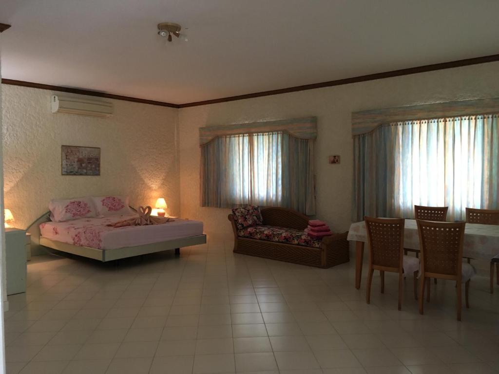 um quarto com uma cama, uma mesa e cadeiras em Peaceful homestay em Rawai Beach