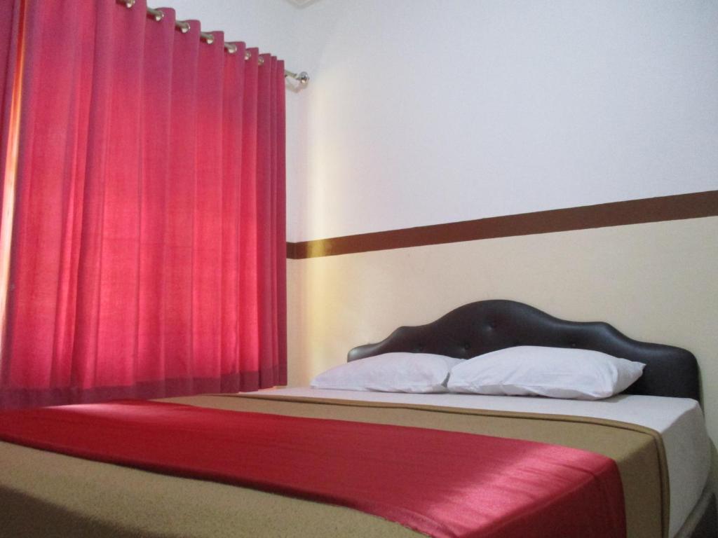 Postel nebo postele na pokoji v ubytování Hotel Tugu Asri