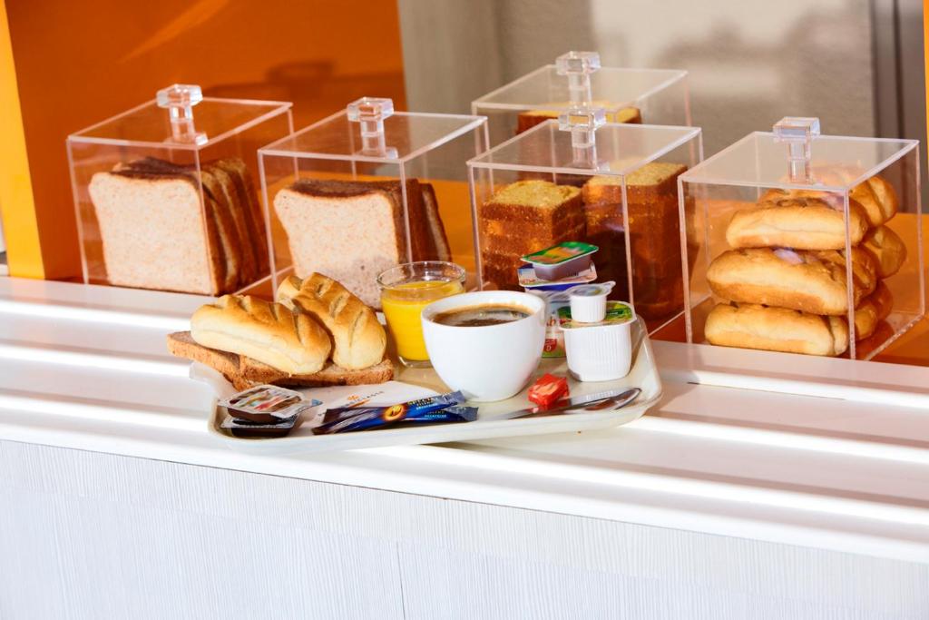 a tray of bread and pastries on a shelf at Première Classe Boulogne sur Mer in Saint-Martin-Boulogne