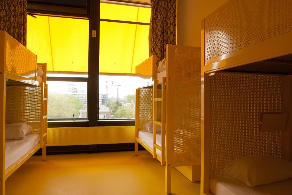 a dorm room with bunk beds and a window at WOW Amsterdam Hostel in Amsterdam