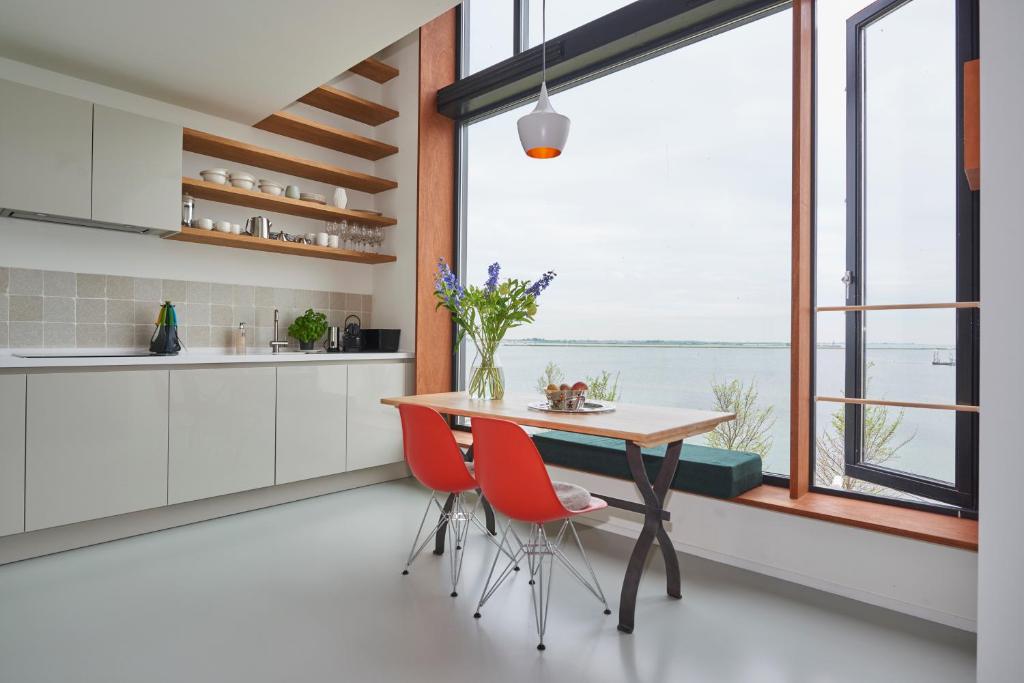 uma cozinha com mesa e cadeiras e uma grande janela em Lake View Apartment Amsterdam em Amsterdã
