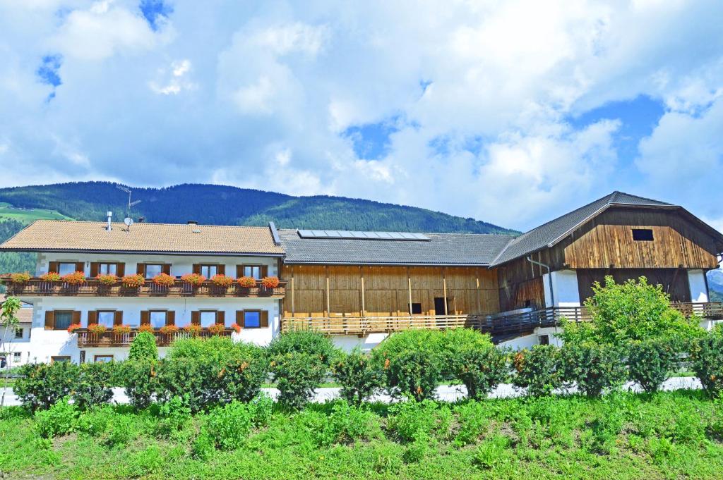 un gran edificio con una montaña en el fondo en Niedermairhof, en Falzes