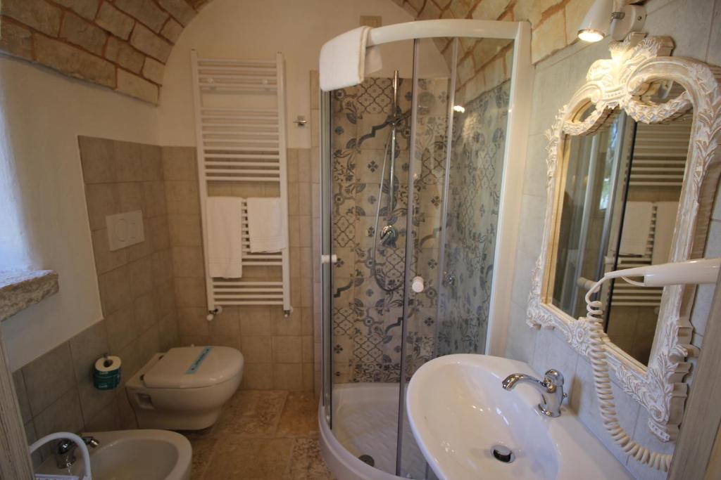 a bathroom with a shower and a sink and a toilet at Il Gabellota Resort in Alberobello