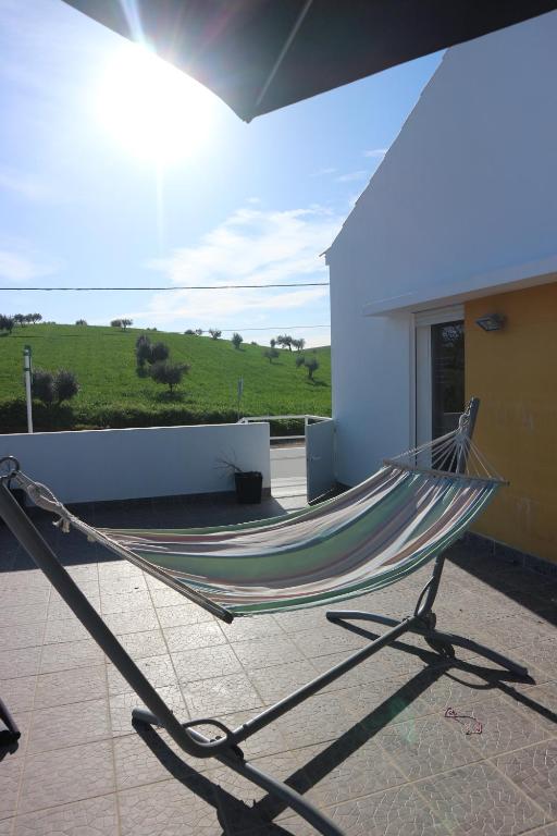 a hammock in front of a building with a view of a field at Casa da Planicie in Évora
