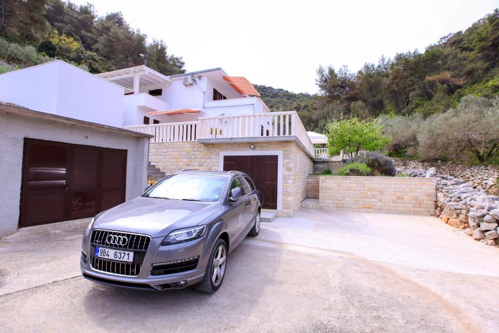 a car parked in front of a house at Robinson Josip in Bogomolje