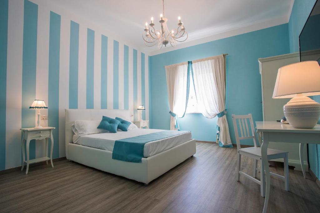 a bedroom with a white bed and a blue wall at Les Suites Magnolia in Olbia
