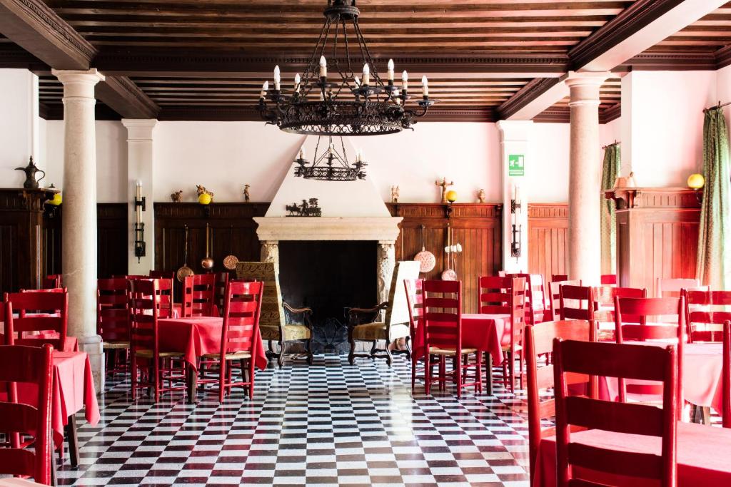a dining room with red chairs and a fireplace at Residenza d'Epoca Albergo Quattro Fontane in Venice-Lido