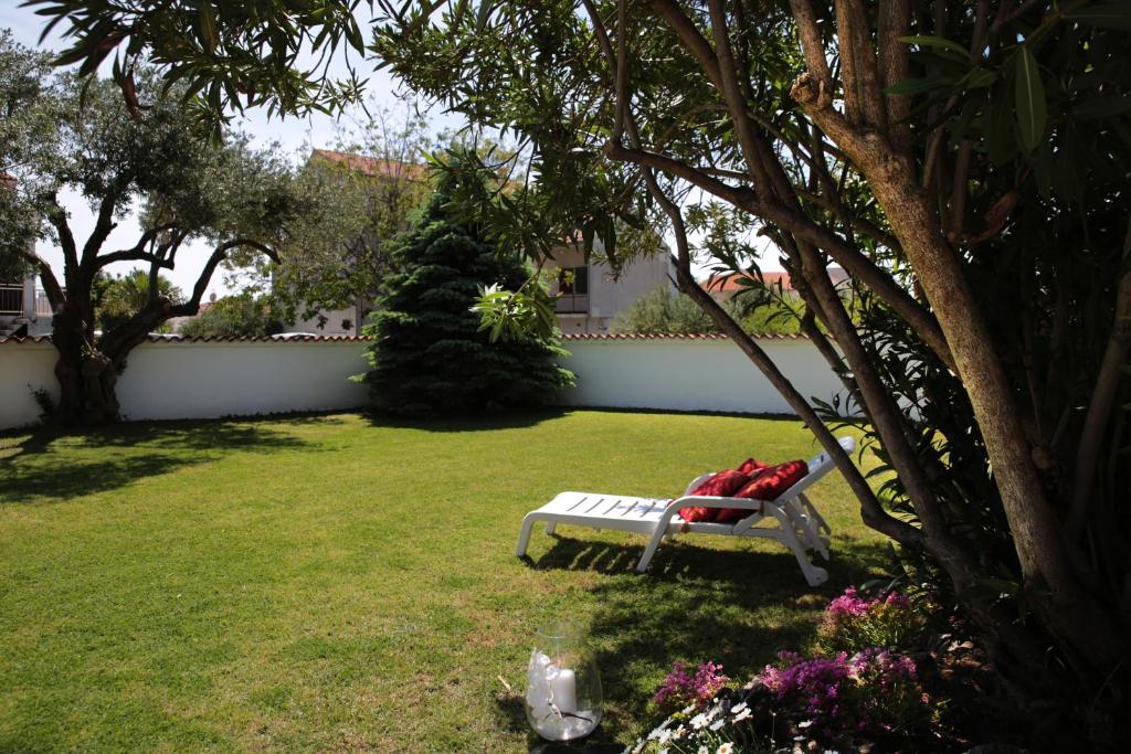 a garden with a bench in the grass at Apartments and Room Anka in Vodice