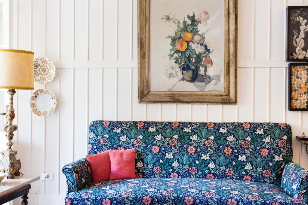 a living room with a blue couch with a vase of flowers at Residenza d'Epoca Albergo Quattro Fontane in Venice-Lido