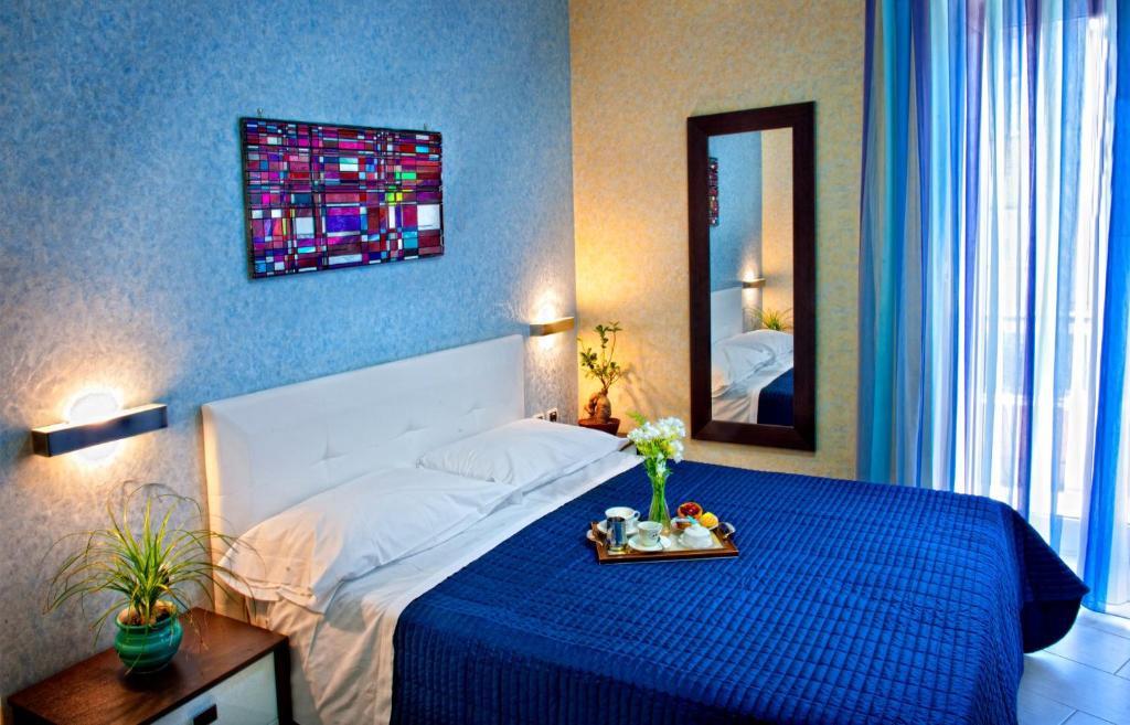 een slaapkamer met een bed met een blauwe deken en een spiegel bij B&B 21-12 in Saviano