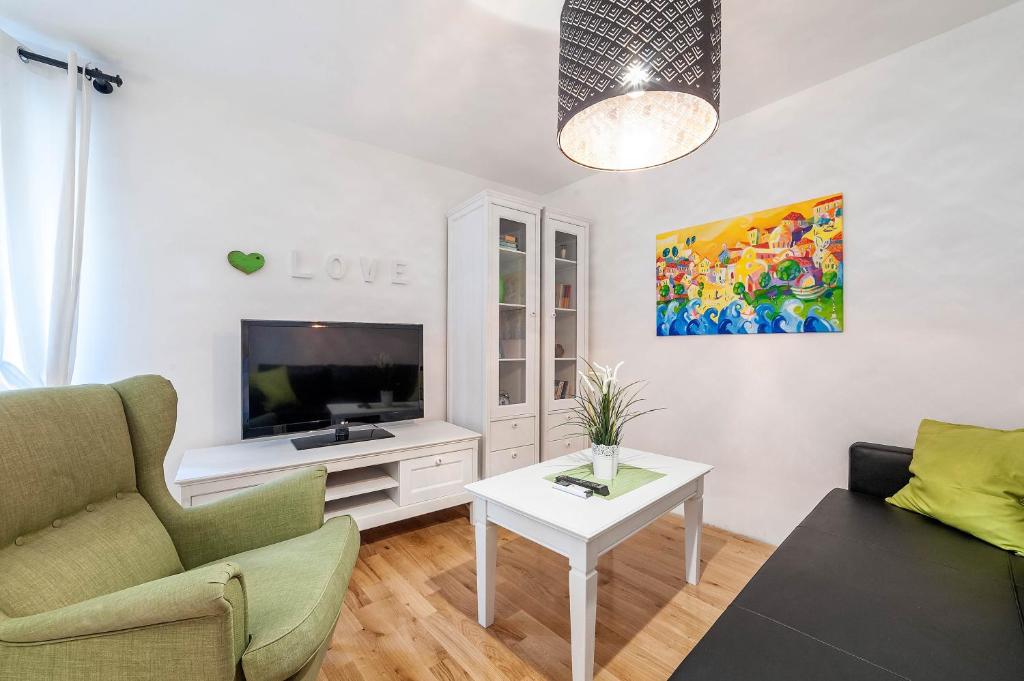 - un salon avec un canapé et une télévision dans l'établissement Apartments Rialto Gallery, à Šibenik