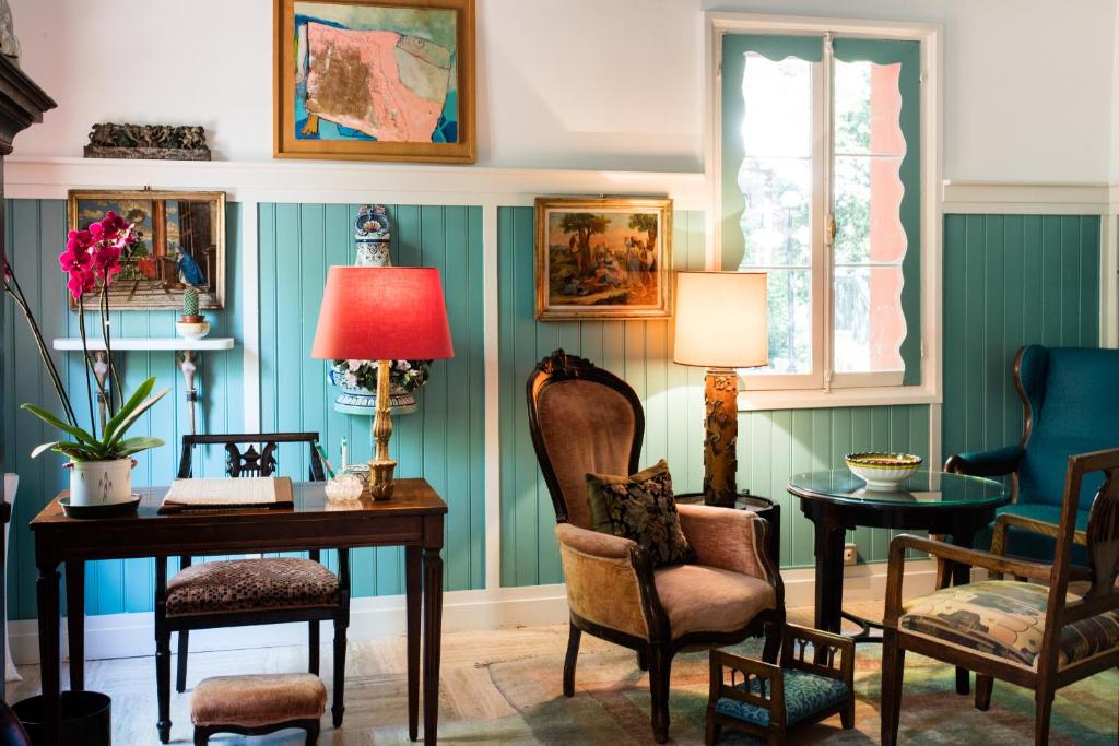a room with a desk and chairs and a lamp at Residenza d'Epoca Albergo Quattro Fontane in Venice-Lido