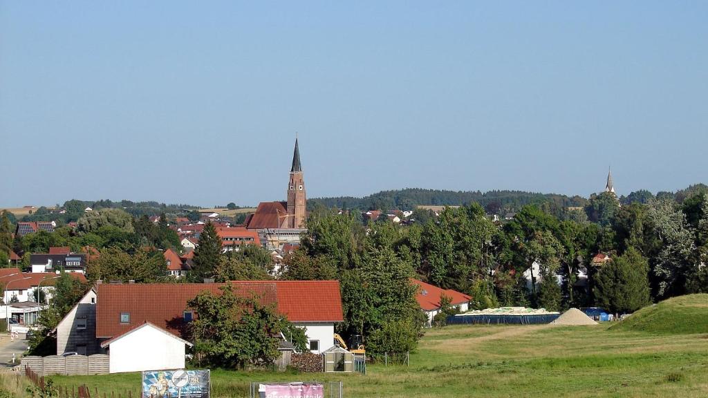 Geisenhausen的住宿－Pension Geno，享有教堂背景的城镇景色