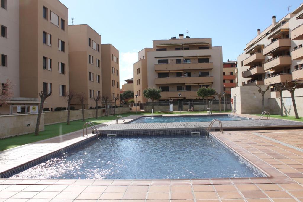 una piscina en un complejo de apartamentos con edificios en Apartamento con piscina a 300m playa Fenals-Lloret, en Lloret de Mar