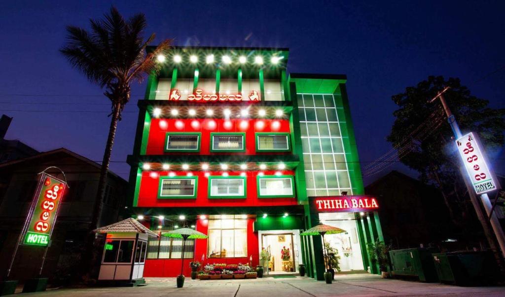 ein rotes und grünes Gebäude mit Licht in der Unterkunft Thiha Bala Hotel in Pyin U Lwin