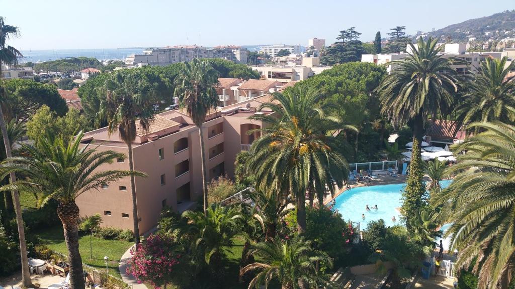 - une vue sur un complexe avec des palmiers et une piscine dans l'établissement Appartement T2 de standing au pied des plages, au Golfe-Juan