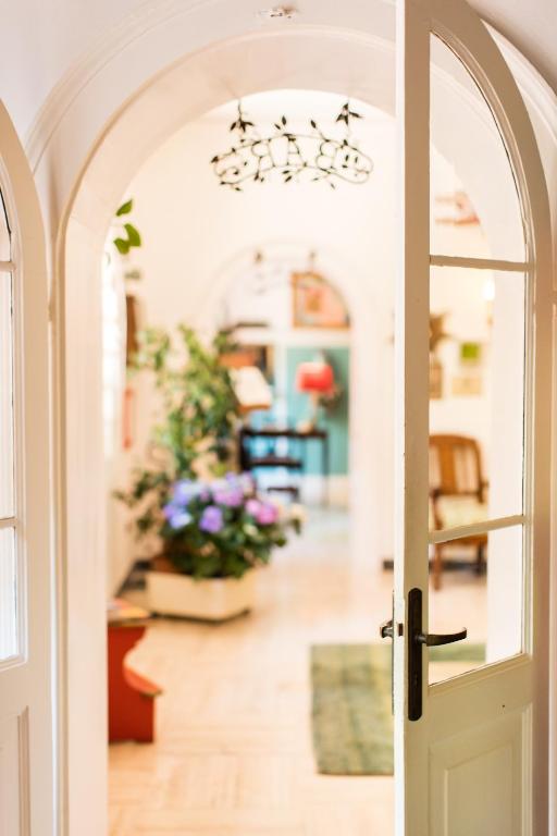 an open door to a living room with flowers at Residenza d'Epoca Albergo Quattro Fontane in Venice-Lido
