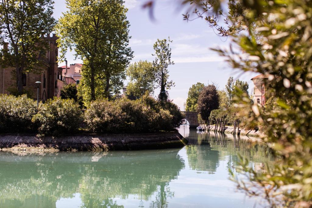 a river in a city with trees and buildings at Residenza d'Epoca Albergo Quattro Fontane in Venice-Lido