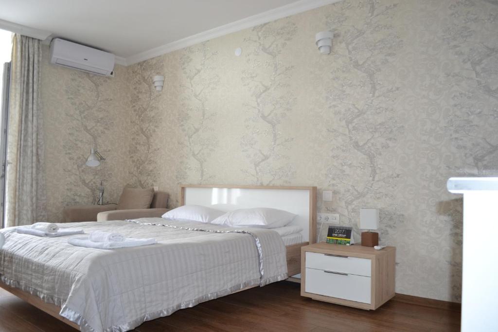 a bedroom with a bed and a wall with wallpaper at Orbi Towers Rooms in Batumi