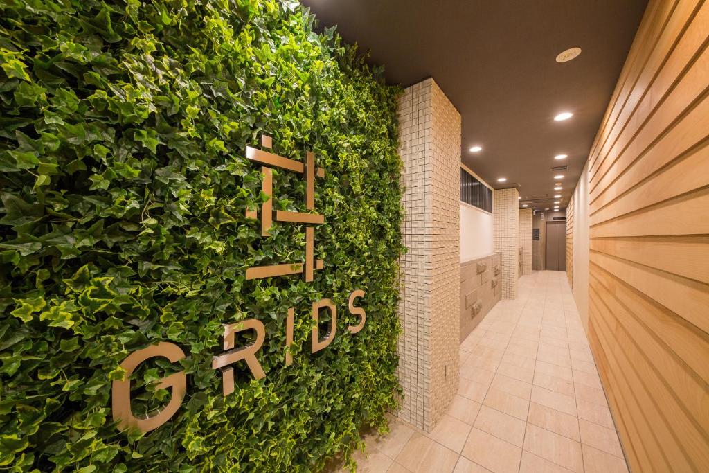a green wall with a bunch of plants in front of it at Grids Sapporo Hotel&Hostel in Sapporo